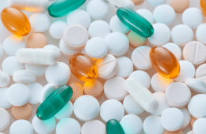 Verschiedene Tabletten und Kapseln auf hellem Hintergrund als Symbol für Wechselwirkungen zwischen Supplementen und Medikamenten.