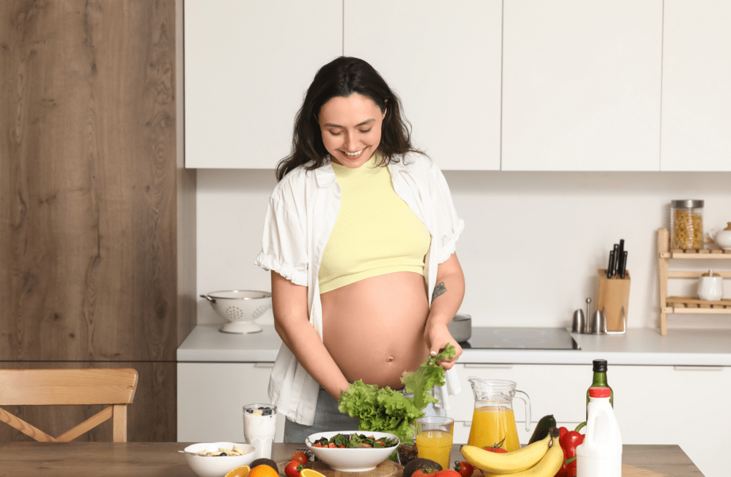 Schwangere Frau bereitet frische Lebensmittel zu und steht beispielhaft für eine ausgewogene Ernährung während der Schwangerschaft zur Vorbeugung von Nahrungsmittelallergien.