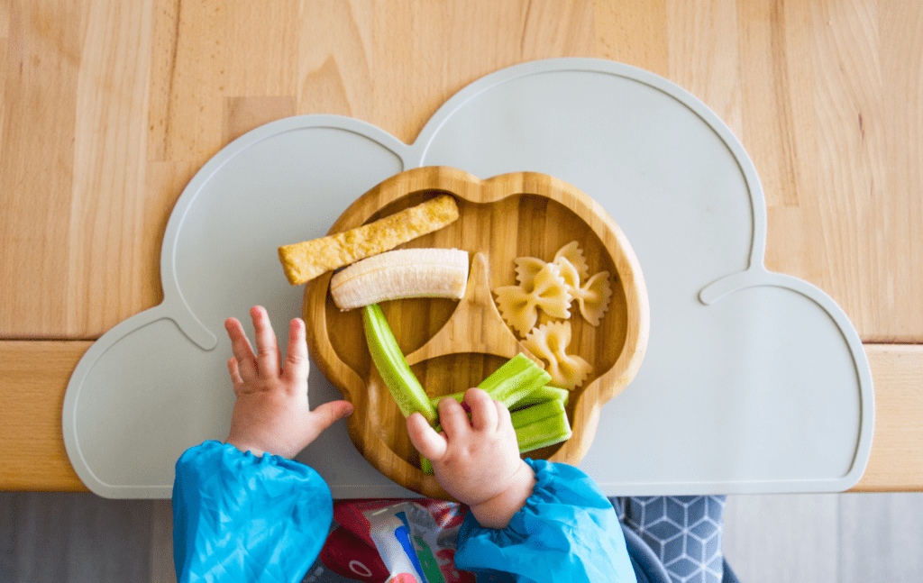 Baby lernt beim Beikoststart verschiedene Lebensmittel kennen, ein wichtiger Schritt zur Vorbeugung von Nahrungsmittelallergien.