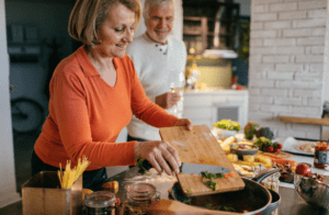 Personen bereiten frisches Gemüse in der Küche zu, um Nährstoffverluste beim Kochen zu vermeiden.