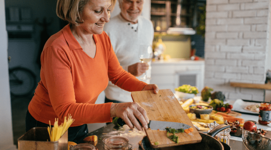 Personen bereiten frisches Gemüse in der Küche zu, um Nährstoffverluste beim Kochen zu vermeiden.